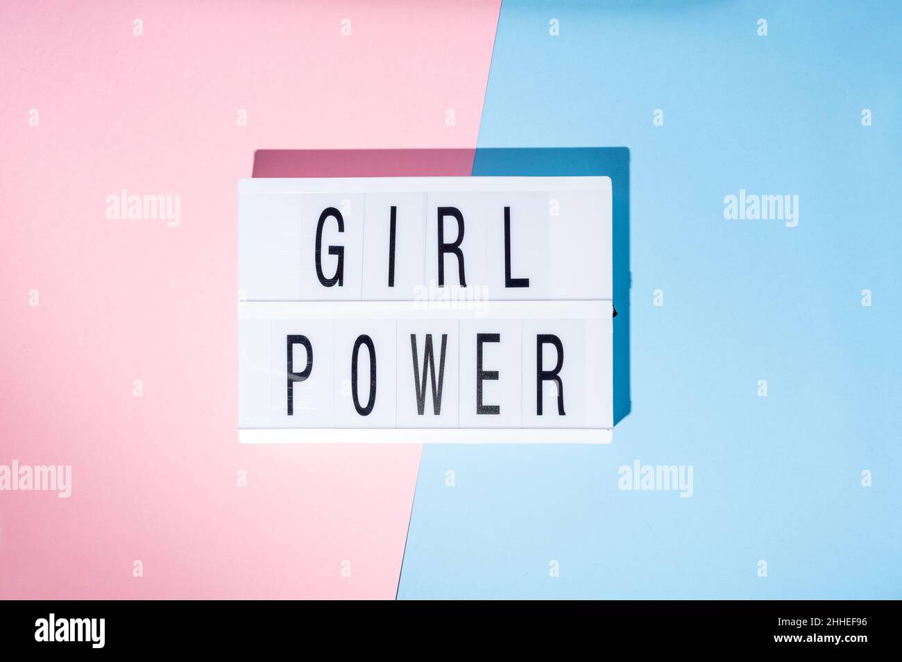 Girl power text on the lightbox. Top view of a concept of feminism with a pink and blue background Stock Photo