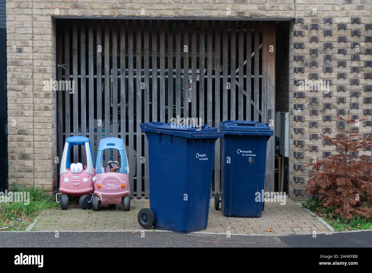 Plastic pedal cars left outside trumpington town house with blue