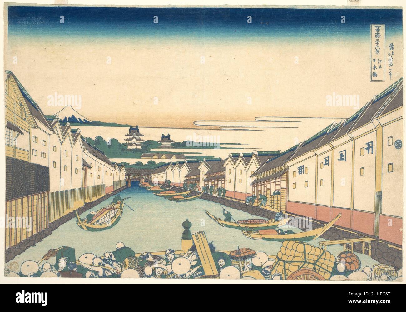 Nihonbashi in Edo (Edo Nihonbashi), from the series Thirty-six Views of Mount Fuji (Fugaku sanjūrokkei) ca. 1830–32 Katsushika Hokusai Japanese Views of the central district of old Edo such as this are frequently characterized by three motifs: the arc of Nihonbashi (literally, 'Bridge of Japan') together with the tiered roofs of Edo Castle and the distant Mt. Fuji. In addition to being the first stage of the Tōkaidō, Nihonbashi's distinctive form and prominent location earned it the importance of a symbol of the capital city.In this composition, Hokusai's radical cropping of the foreground bri Stock Photo