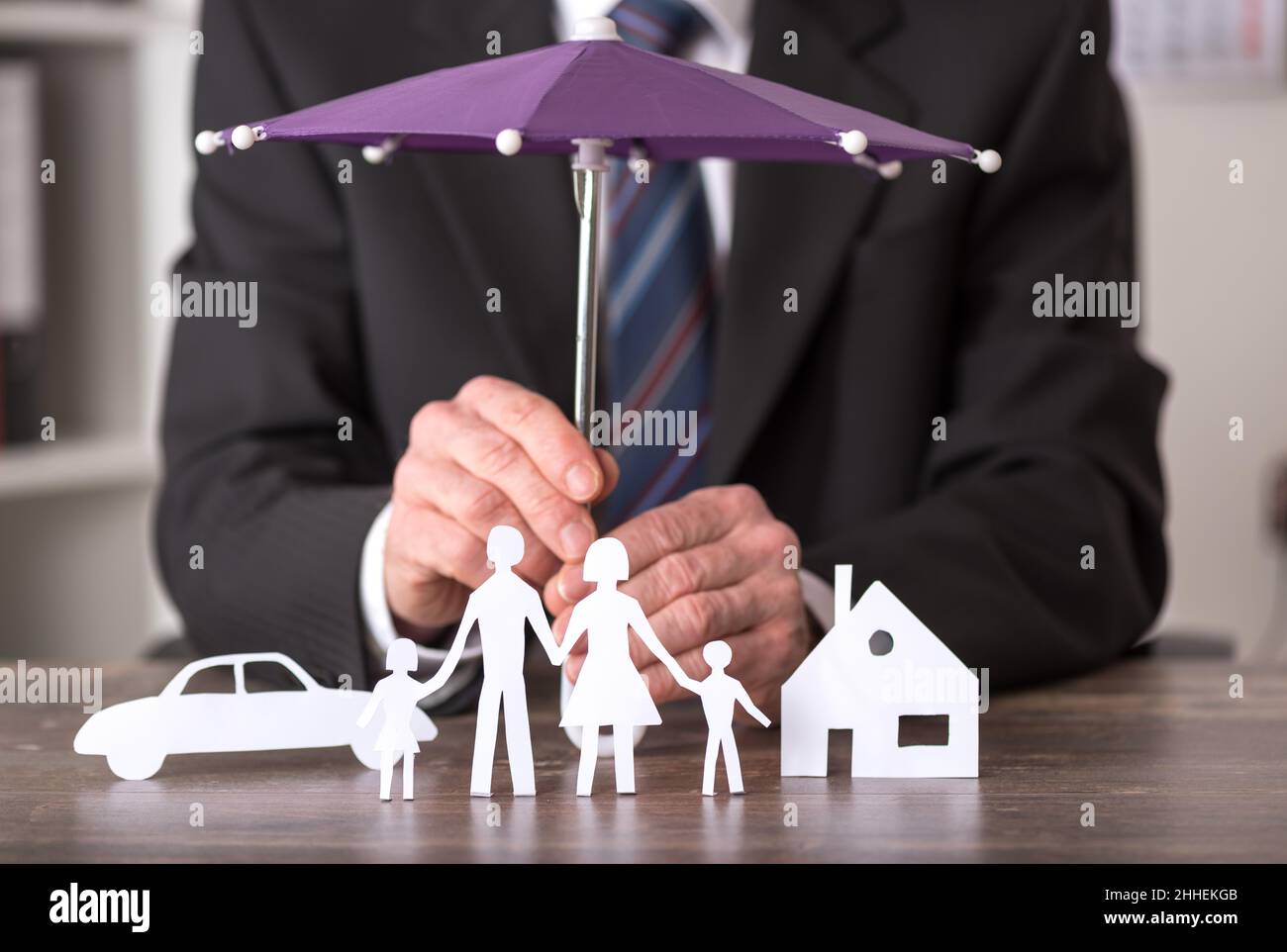 Concept of insurance with umbrella over a house, a car and a family