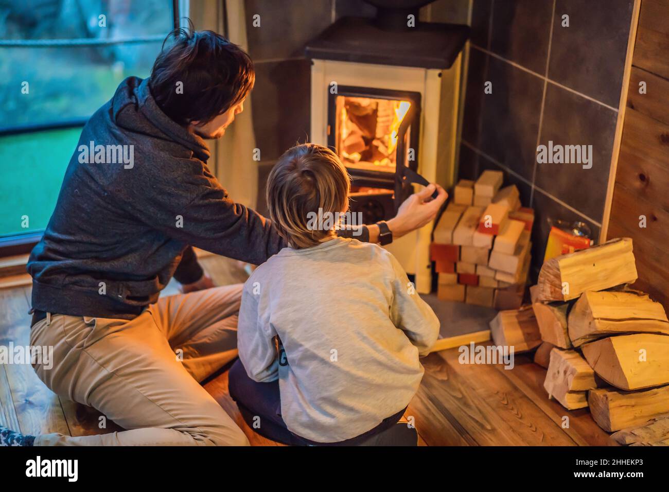 Dad and son spend time by the fireplace in Glamping. Rest in the mountains  in Glamping. Cozy fireplace in a mountain house Stock Photo - Alamy