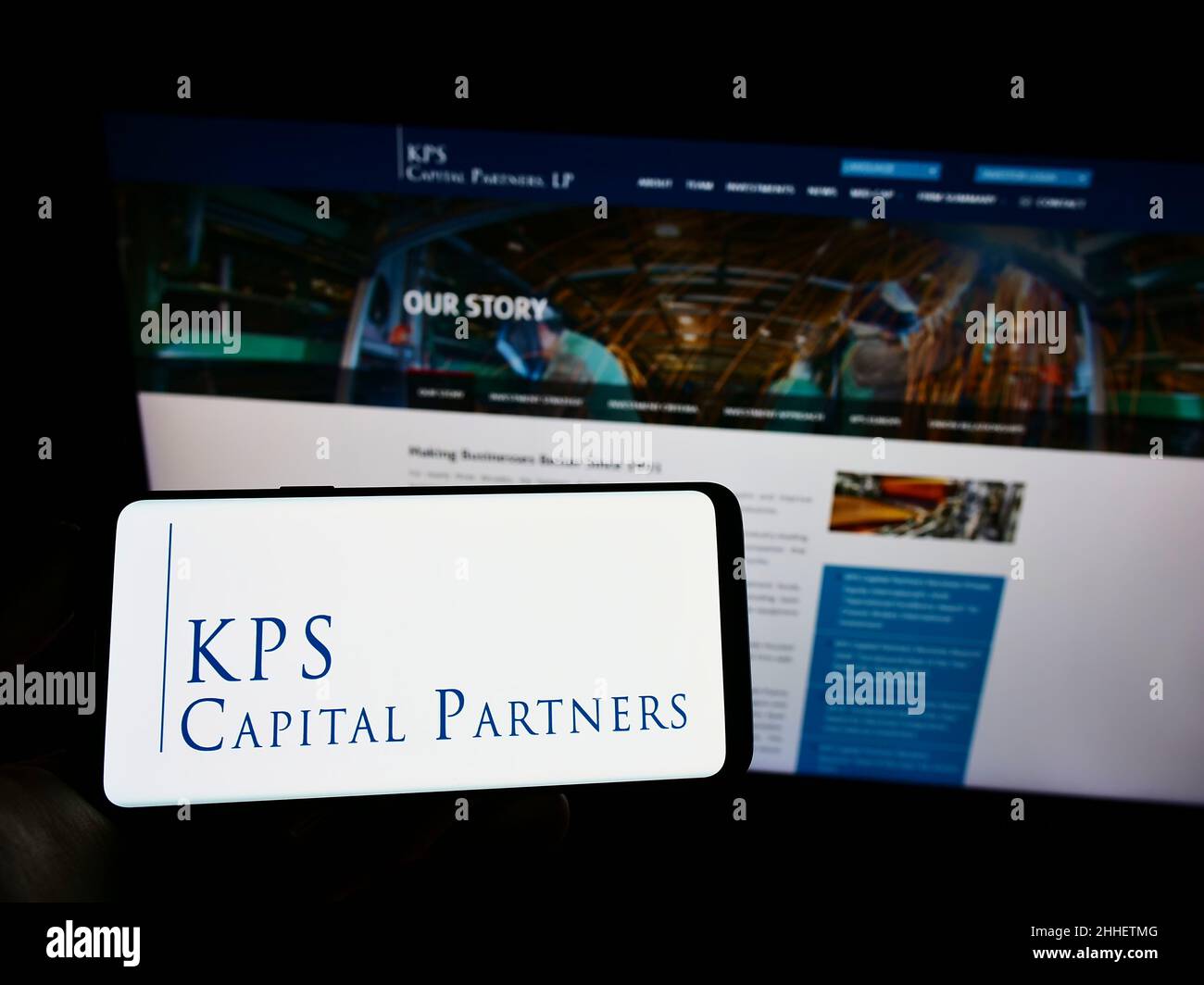 Person holding mobile phone with logo of US investment company KPS Capital Partners LP on screen in front of web page. Focus on phone display. Stock Photo