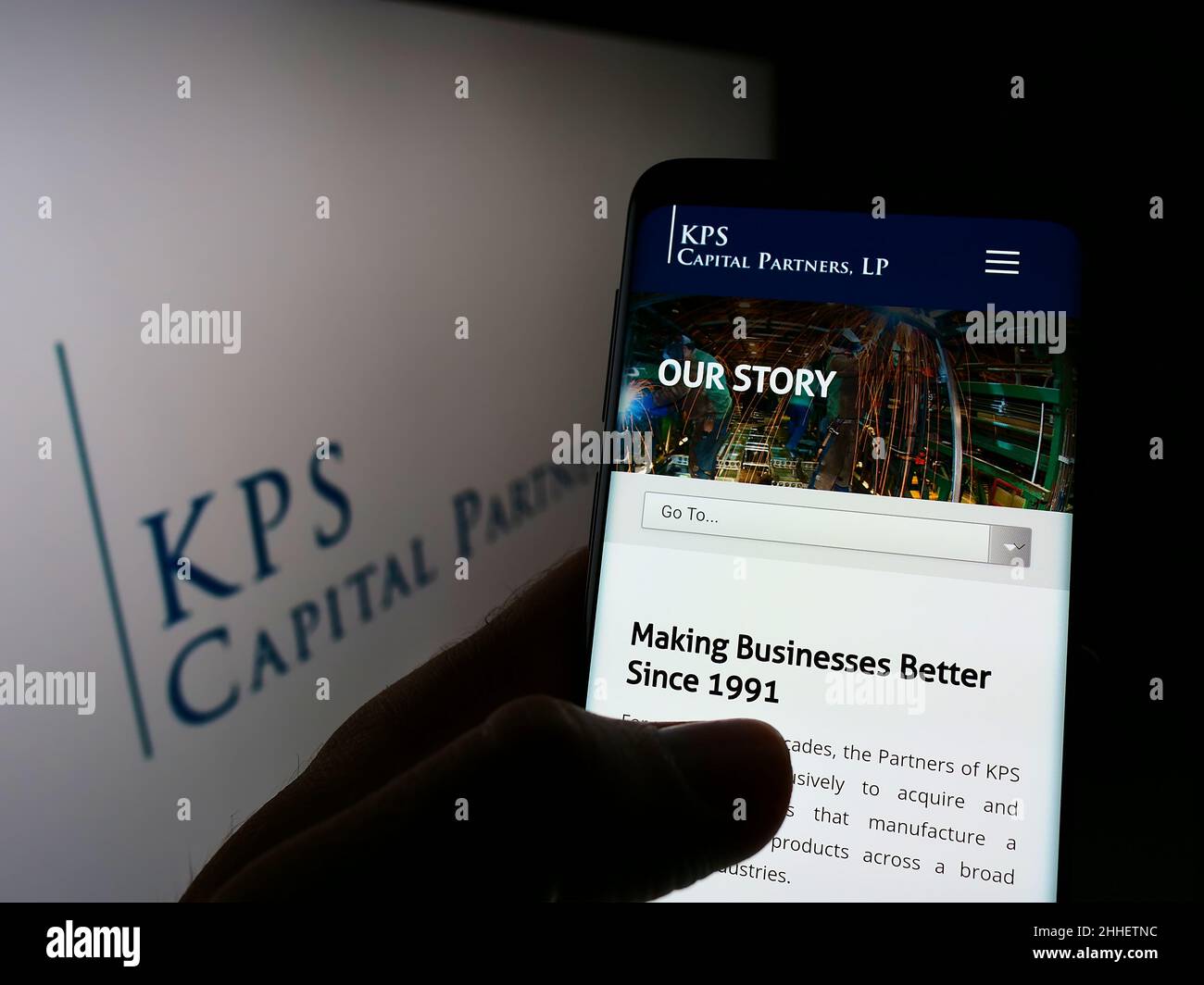 Person holding cellphone with webpage of US investment company KPS Capital Partners LP on screen with logo. Focus on center of phone display. Stock Photo