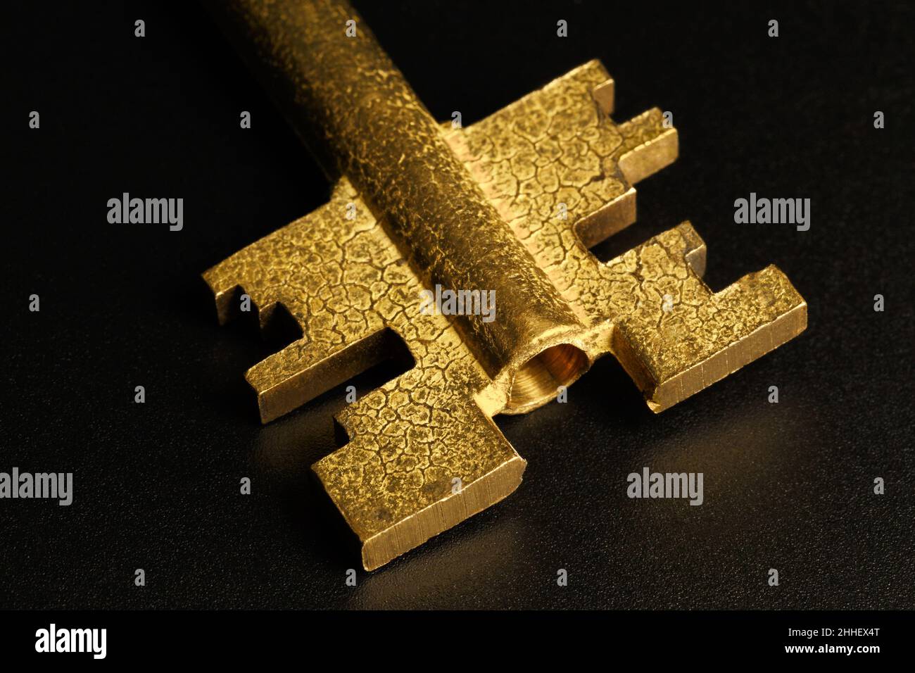 Brass key bit on a dark background. Macro photography Stock Photo