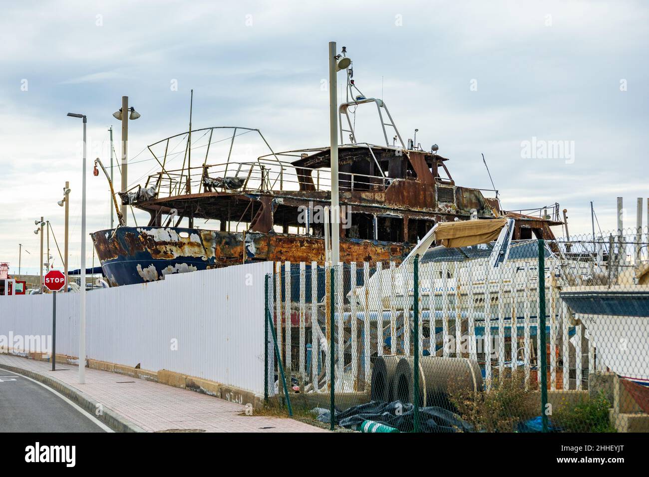 Fire Damaged, Burnt Out Boat at Garrucha Shipyard, Spain Stock Photo