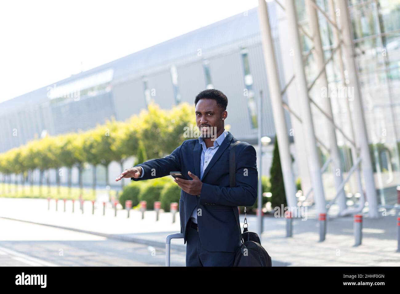 Young businessman after arriving. Comfortable airport, work trip, business  lifestyle. African-american male model with luggage after coming to end  point of his trip. Leaving terminal with documents Stock Photo - Alamy