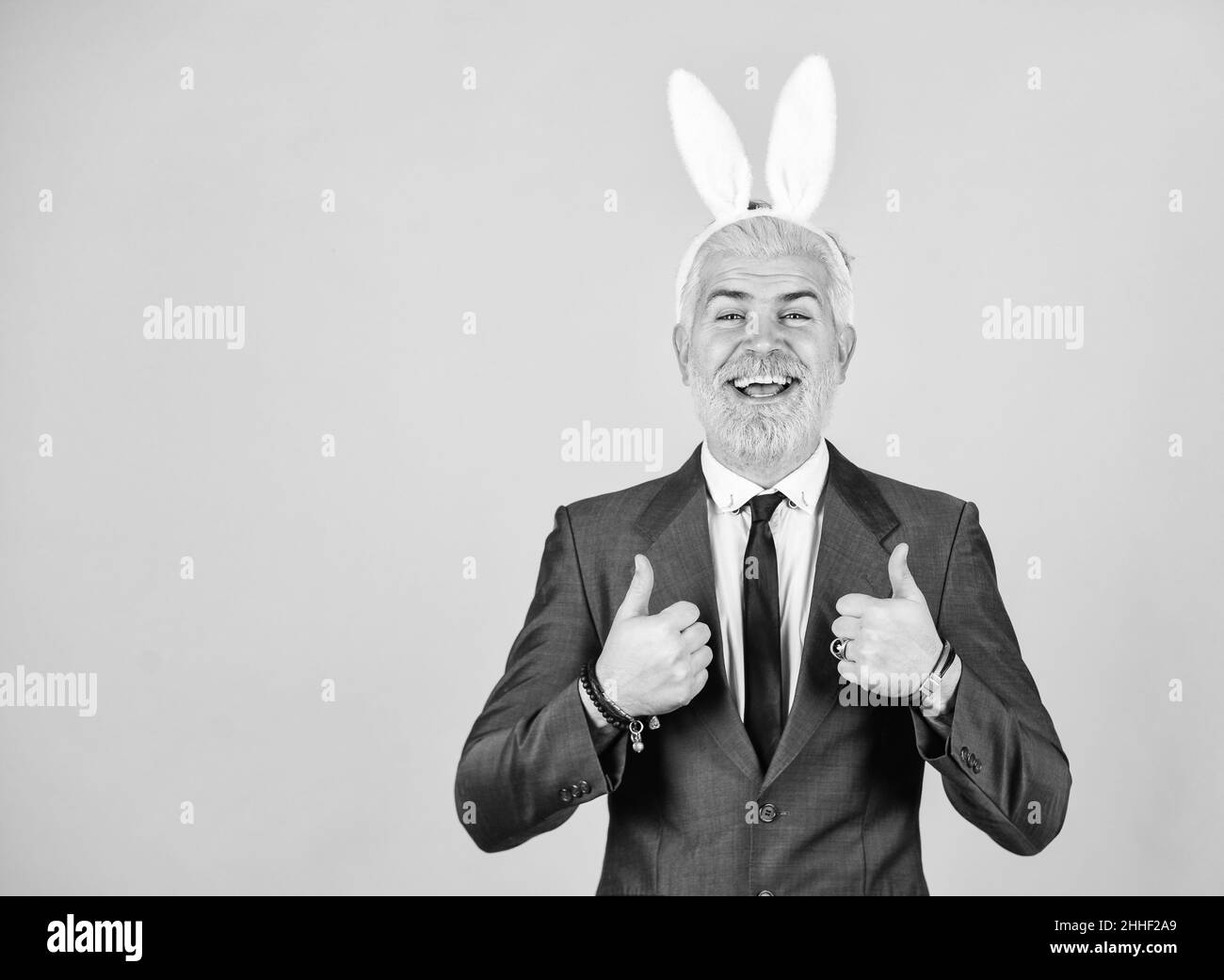 Bring out your inner rabbit. Easter rabbit. Happy businessman wear rabbit ears. Bearded man show thumbs ups. Rabbit costume party. Festive holiday Stock Photo