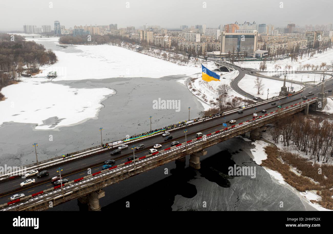 KYIV, UKRAINE - JANUARY 22, 2022 - A 216 sq.m. flag of Ukraine carried by cargo drones flies above Paton Bridge across the Dnipro River on Unity Day, Stock Photo