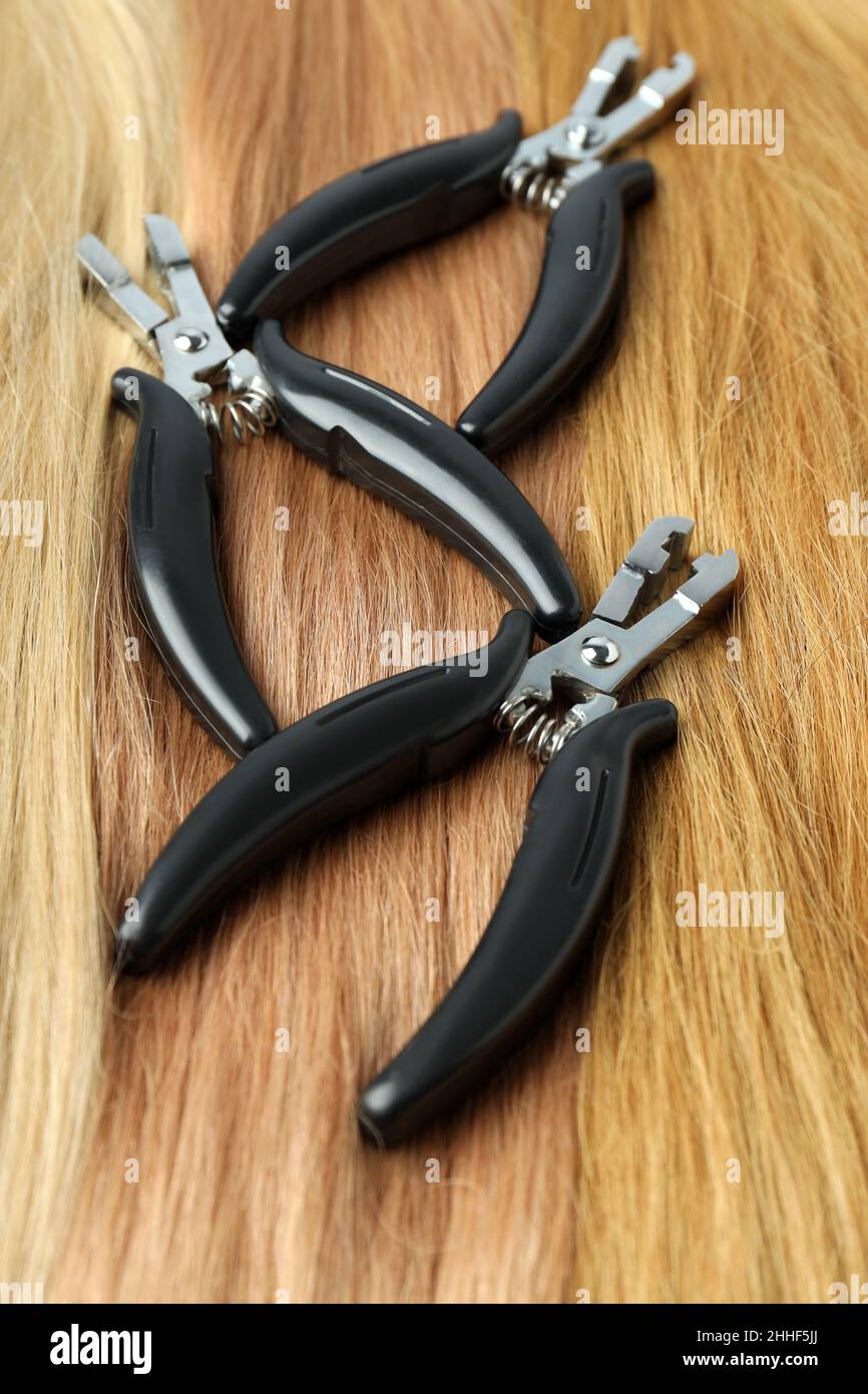 Female hair and hair extension tongs, close up Stock Photo - Alamy