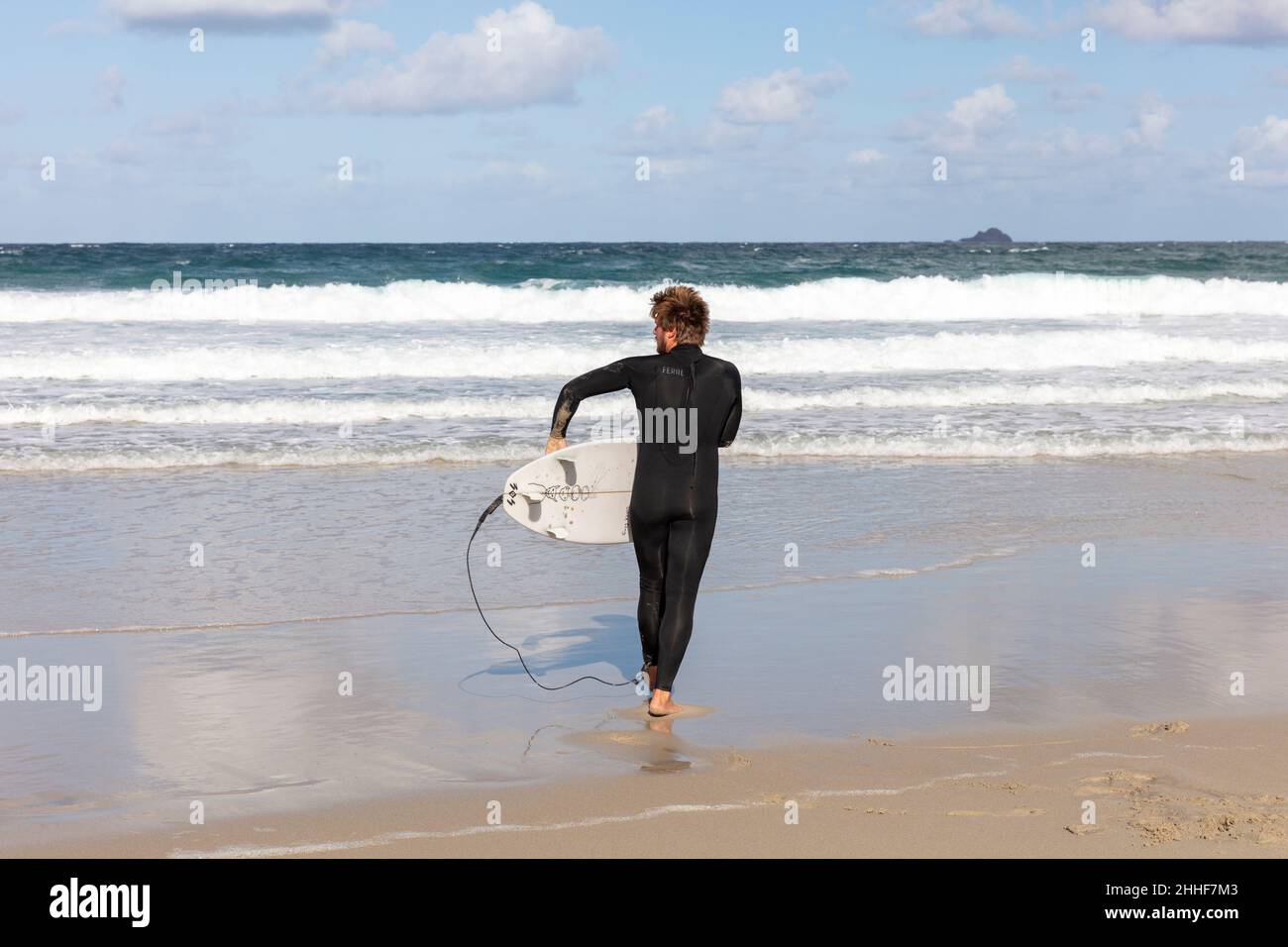 Surfer, surfer and surfboard, surfboard, Hayle beach, Cornwall, UK, England, Cornwall surfer, Cornwall surfboarding, surfboarder, surf boarder, sea Stock Photo