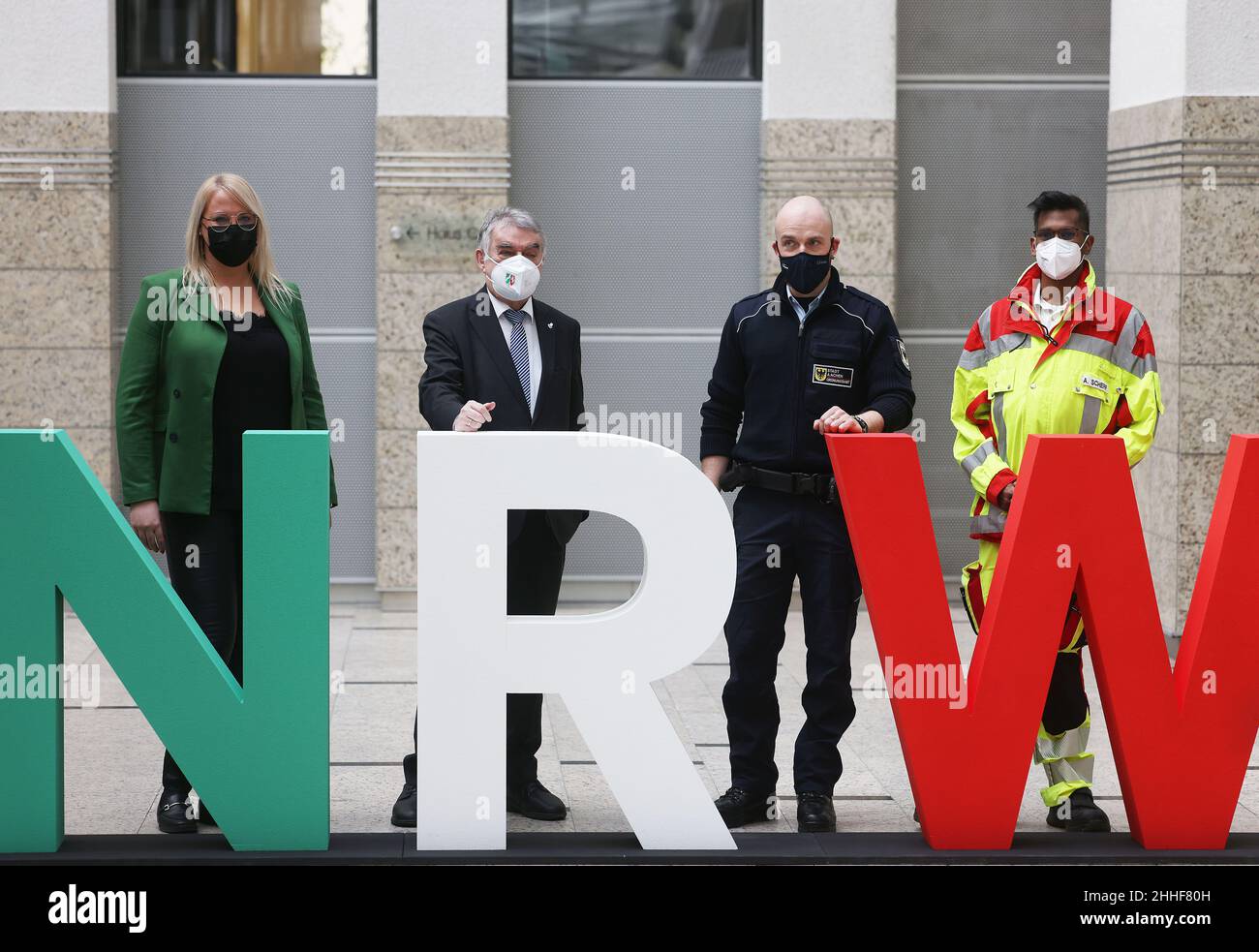 Duesseldorf, Germany. 24th Jan, 2022. Herbert Reul (CDU, 2nd from left), Interior Minister of North Rhine-Westphalia, stands with public service employees Sven Nütten (2nd from right), Adrian Scherf (r) and Nicole Schorn at a logo of the state of North Rhine-Westphalia. The Minister of the Interior of North Rhine-Westphalia has presented the state-wide prevention network '#sicher im Dienst'. The new network is designed to protect public service employees from threats and violence. Credit: Oliver Berg/dpa/Alamy Live News Stock Photo
