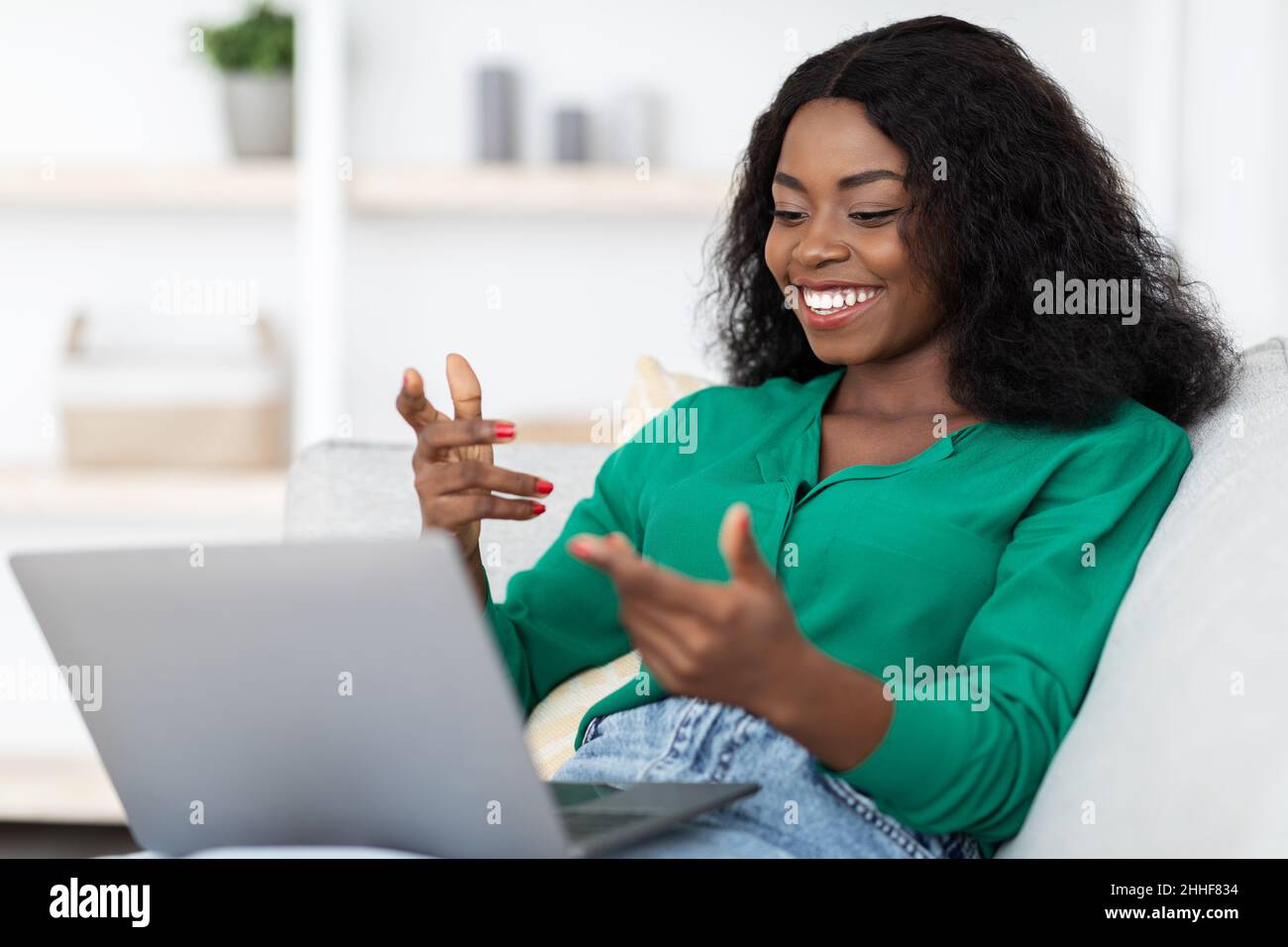 Chatty african american woman having video call, using laptop Stock Photo