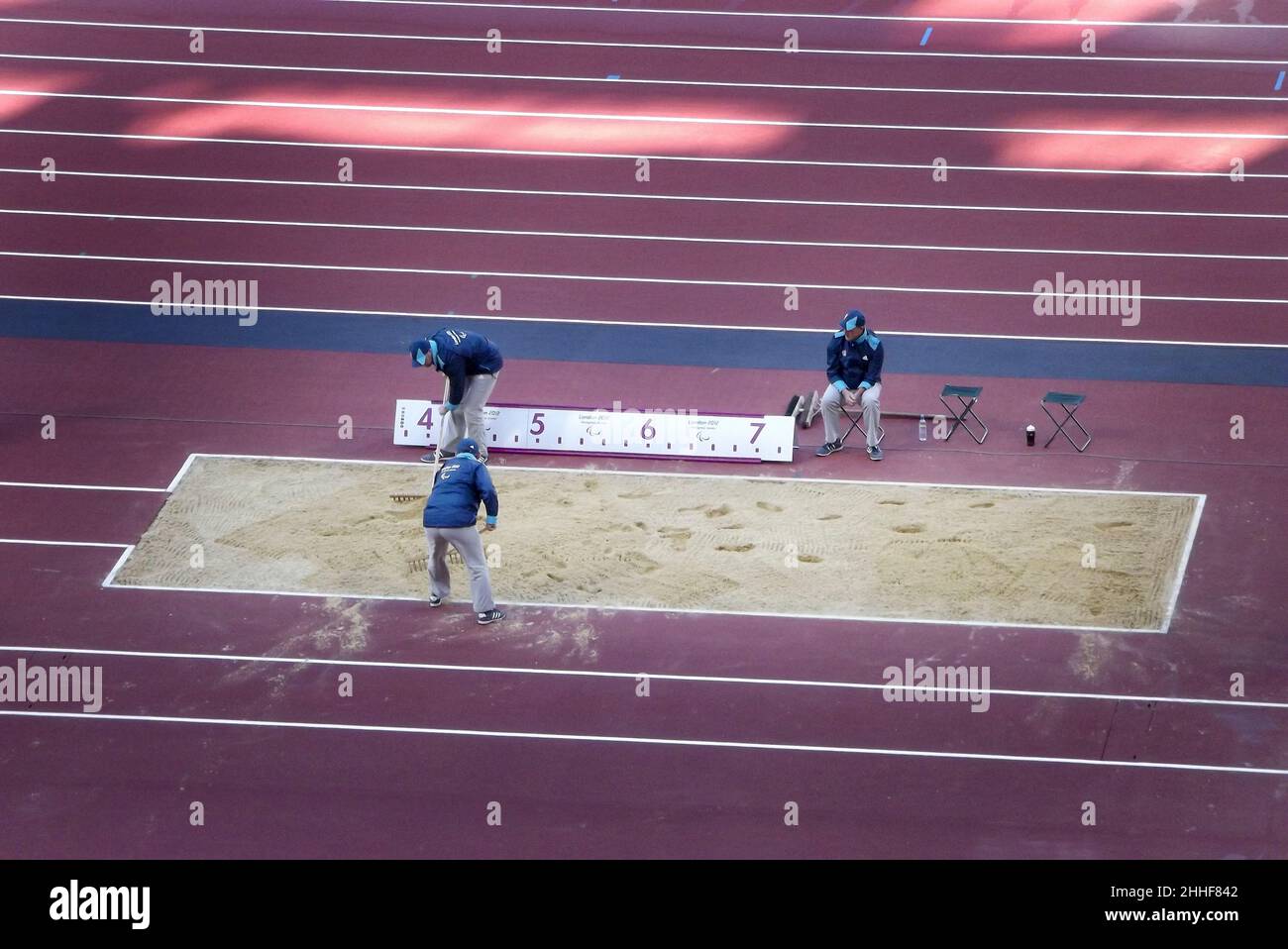 People raking the sand on the long jump sand pit at the Queen Elizabeth Park during the