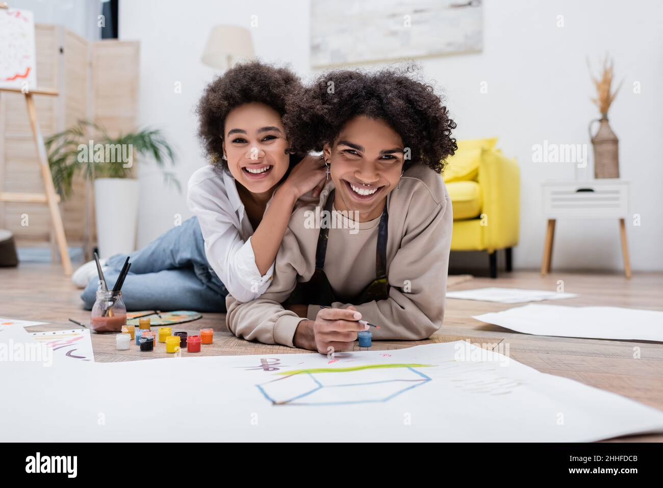 Happy african american woman hugging boyfriend and looking at camera ...