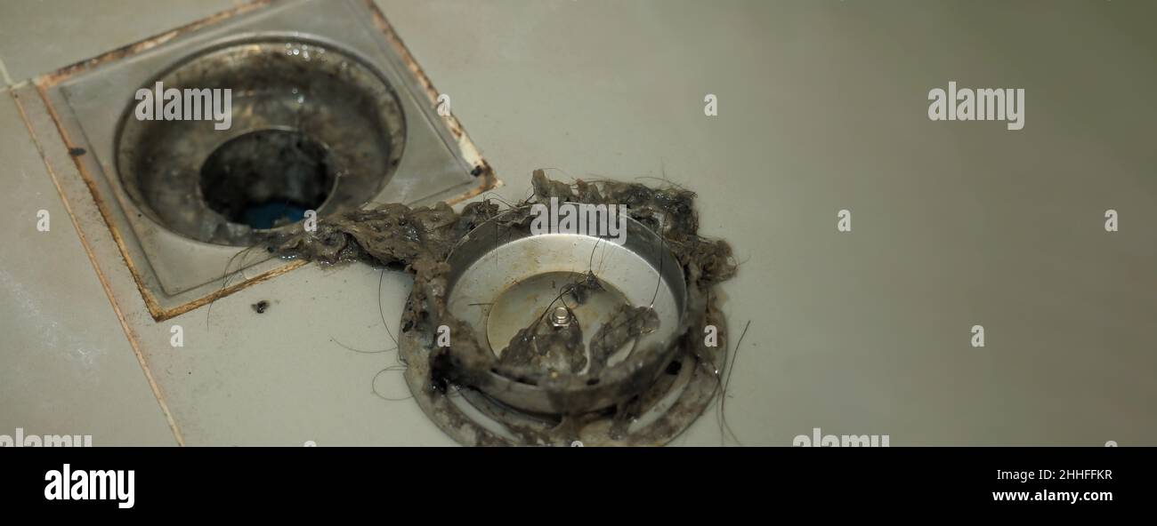 Drain cleaning. Clogged and dirty sewer pipes floor drain. Full of hair