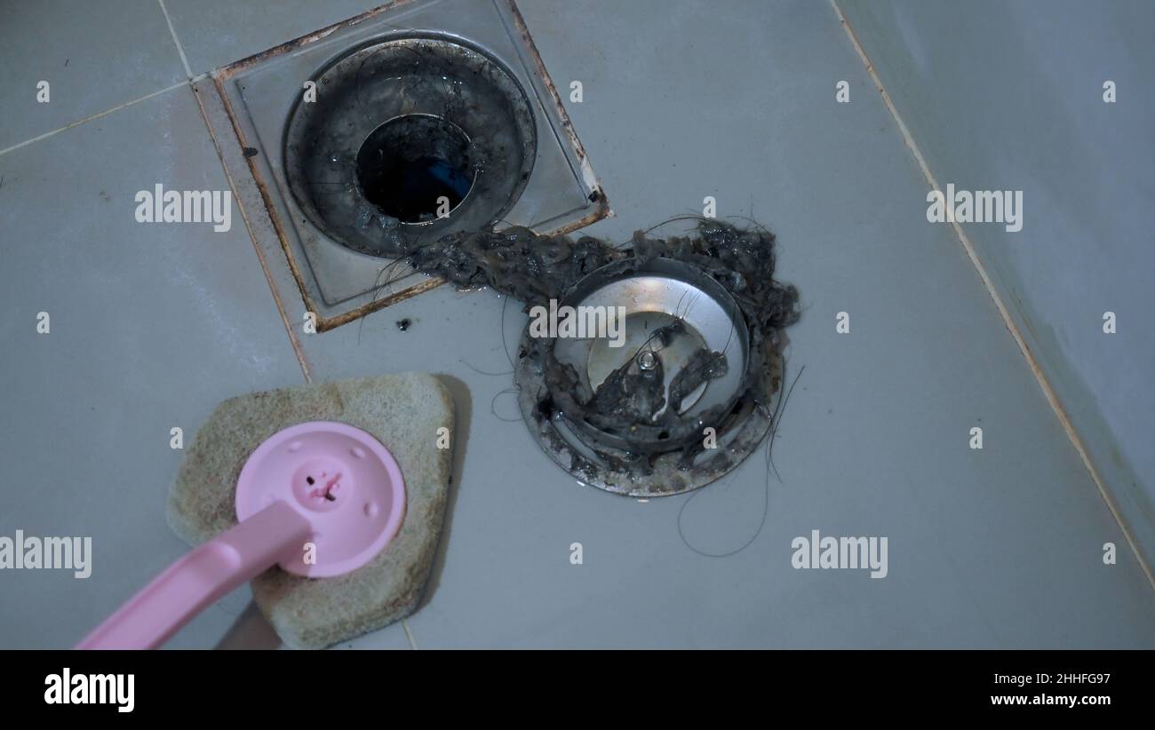 Drain cleaning. Clogged and dirty sewer pipes floor drain. Full of hair