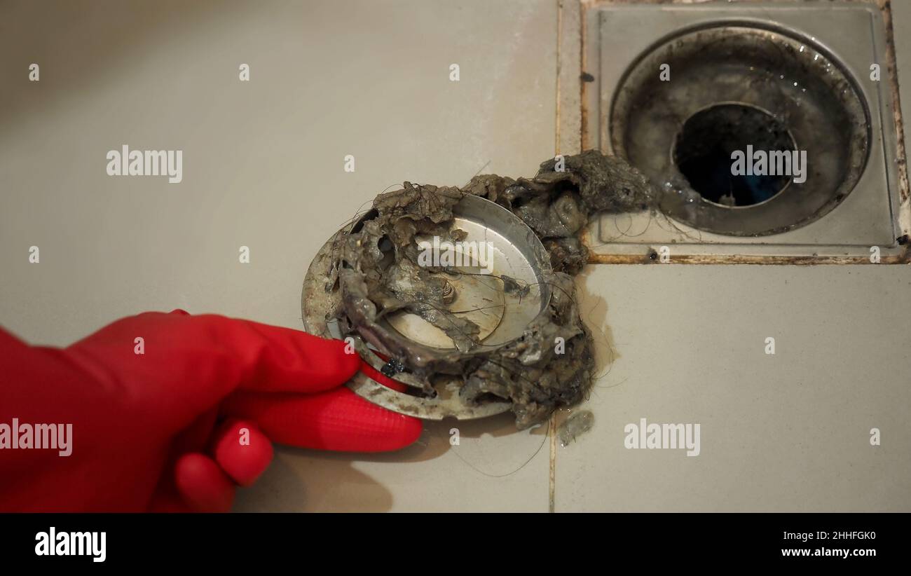 Drain cleaning. Clogged and dirty sewer pipes floor drain. Full of hair