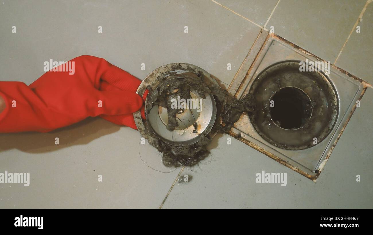 Drain cleaning. Clogged and dirty sewer pipes floor drain. Full of hair