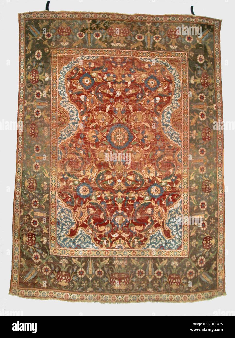 Carpet 17th century The scalloped horseshoe arch and overall floral field are characteristic of a small group of Ottoman rugs. Some, with all-wool construction, are thought to come from Cairo, a well-established rug-weaving center when it was conquered by the Ottomans in 1517. While continuing the use of the Senneh or Persian knot and limited palette of colors of the geometric patterned carpets made under Mamluk rule, the Cairo weavers employed totally Ottoman elements in their designs. In the center of the field is a configuration of a rosette type blossom surrounded by palmettes, a device wh Stock Photo