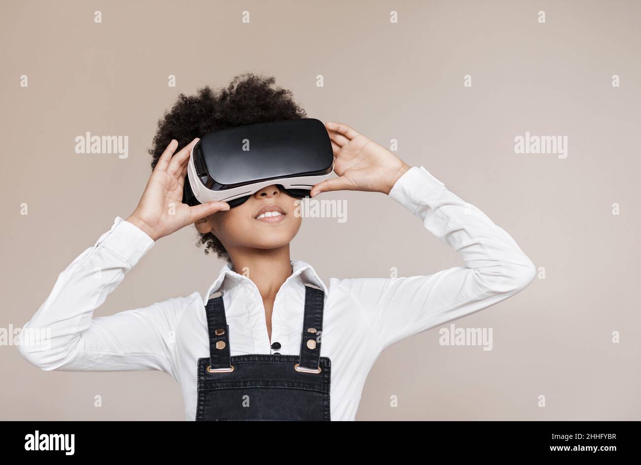 Cute little girl using virtual reality headset. Funny child having fun. VR, future, gadgets, technology, education online, studying concept Stock Photo