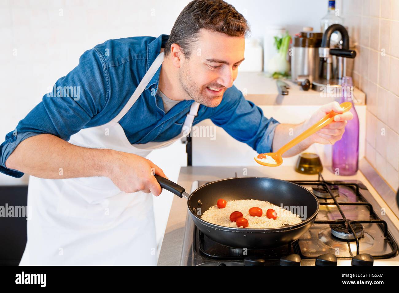 https://c8.alamy.com/comp/2HHG5XM/man-tasting-food-recipe-with-spoon-in-the-kitchen-at-home-2HHG5XM.jpg