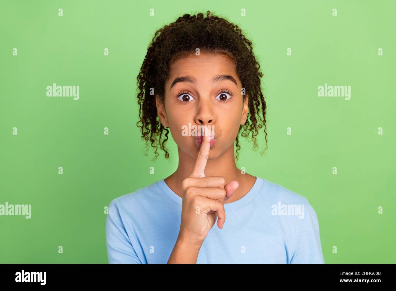 Portrait of attractive trendy girl showing shh sign keep silence isolated over green pastel color background Stock Photo