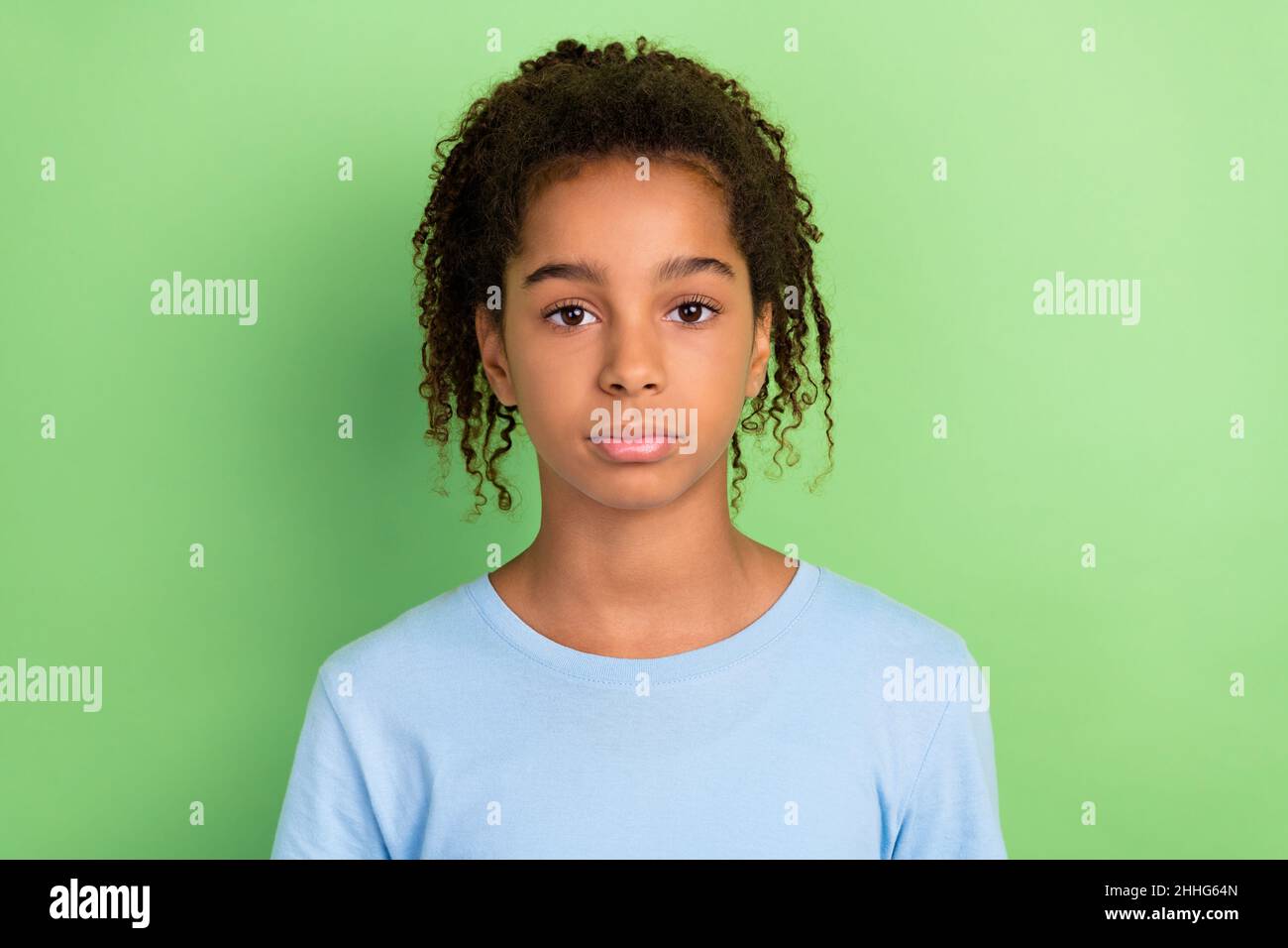 Photo of young african little school girl teen serious confident isolated over green color background Stock Photo