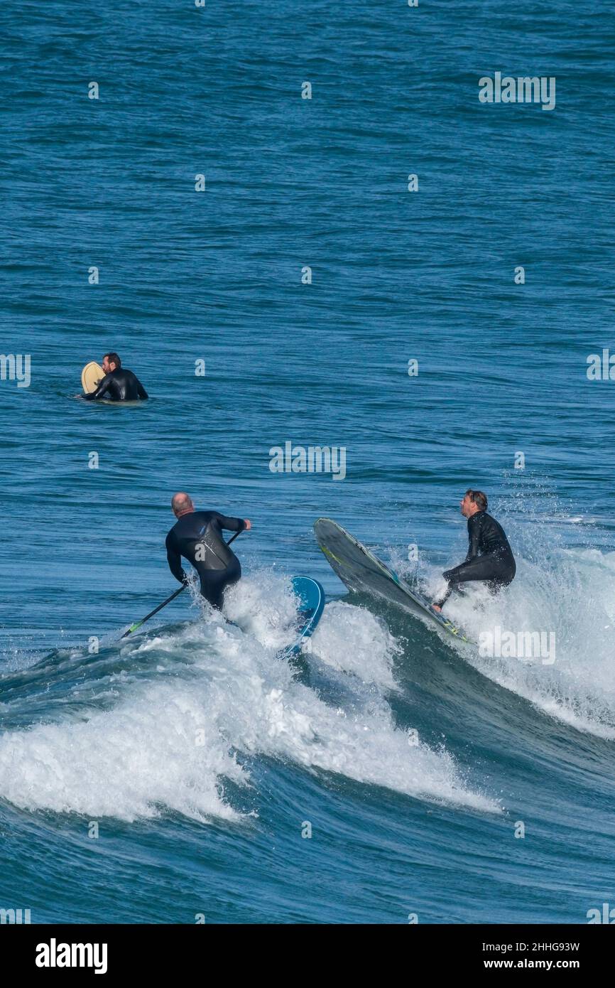 A Stand Up Paddleboarder about to collide with a surfer at Fistral in Newquay in Cornwall. Stock Photo