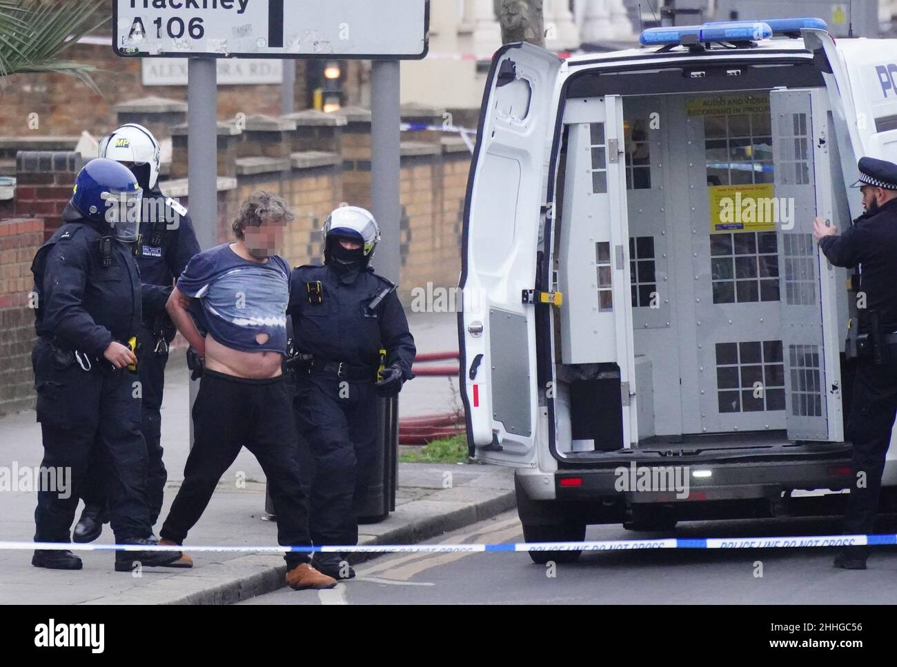 FACE PIXELATED BY PA PICTURE DESK A man is led away from a house by police after an incident on High Road, Leyton, east London. Picture date: Monday January 24, 2022. Stock Photo