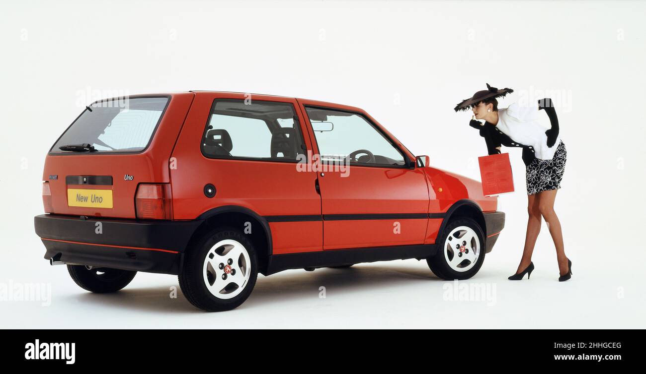 Young woman with a 1989 Fiat Uno with Stock Photo