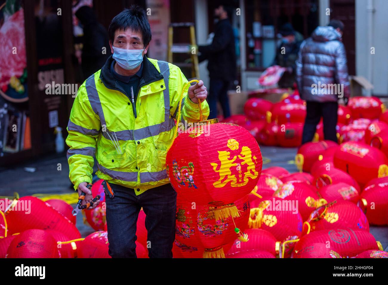 London, UK.  24 January 2022.   A workman carries an assembled lantern in Chinatown ahead of Chinese New Year and The Year of the Tiger officially begins on 1 February.  Festivities on Chinatown are scaled back this year to the pandemic.  Credit: Stephen Chung / Alamy Live News Stock Photo