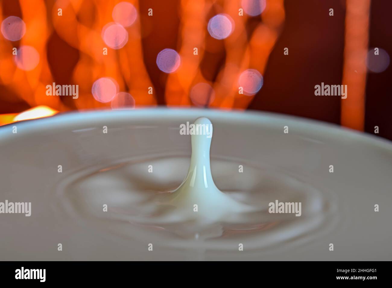Drops falling on a container, with a bokeh background. Stock Photo