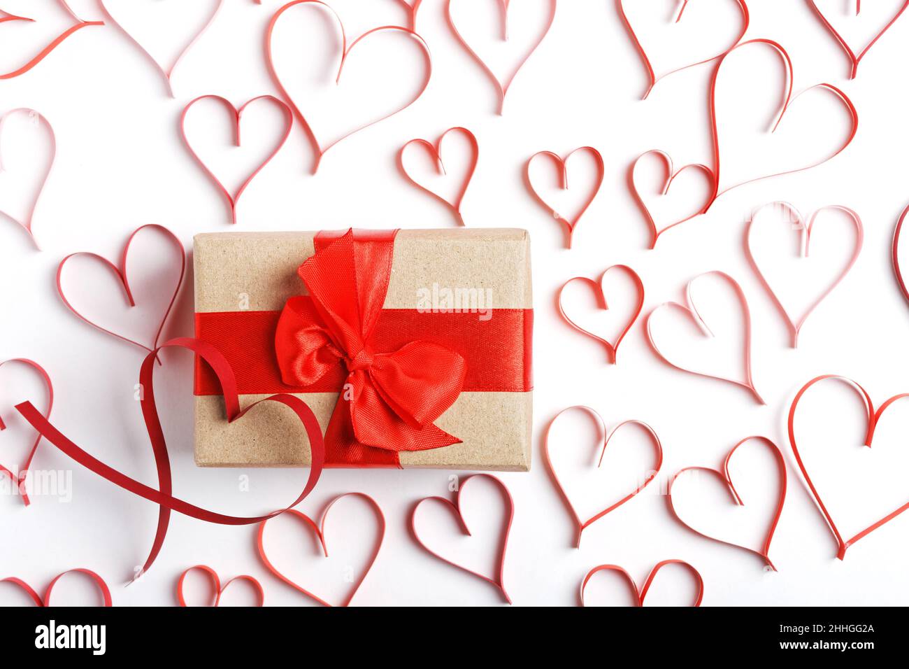 Box with gift wrapped in kraft paper and tied with red ribbon ...