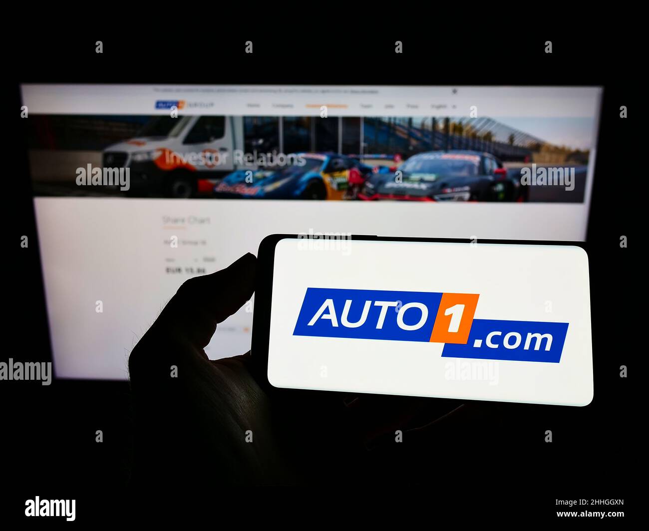 Person holding cellphone with logo of German car dealing company Auto1