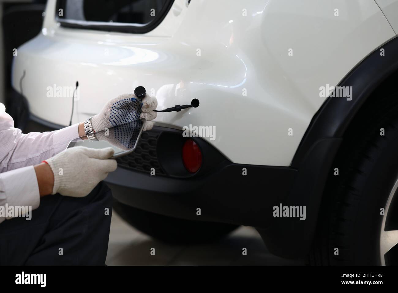 Mechanic installs parking sensors on car closeup Stock Photo Alamy