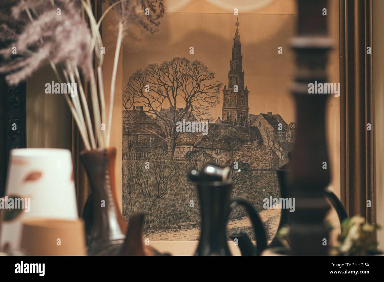 Ancient lithography depicting The Church of Our Savior, a baroque church in Copenhagen, Denmark in an old frame with vintage vases and lamp Stock Photo