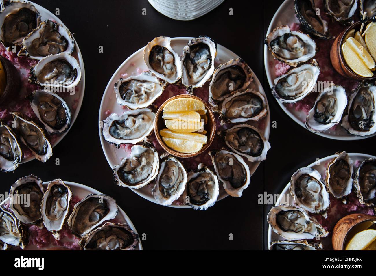 Fresh oysters on plate, served table with oysters, lemon in restaurant. Gourmet food. Stock Photo