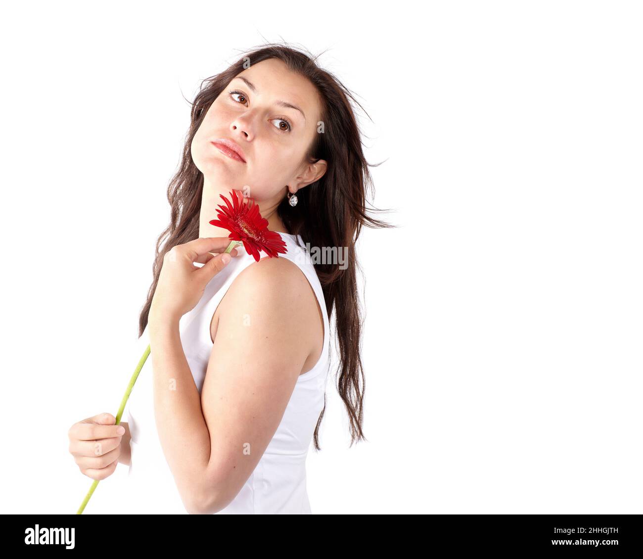 Spring portrait of young woman with healthy long hair holding red gerbera flower. Beautiful female model face. Isolated on white background. Stock Photo