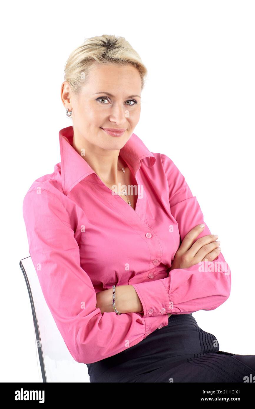 Portrait of a businesswoman sitting three-quarters on a chair and looking to the camera, isolated on white background Stock Photo