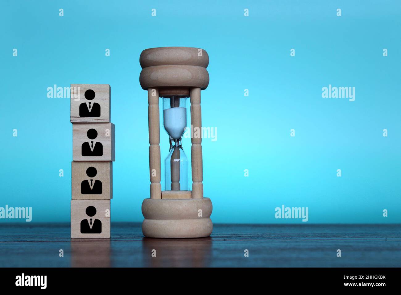 Working hours, hourly wages, deadline concept. Hourglass and wooden