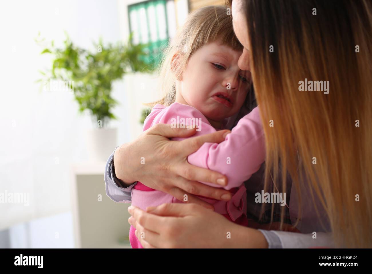 Mother consoles crying baby girl home closeup Stock Photo - Alamy