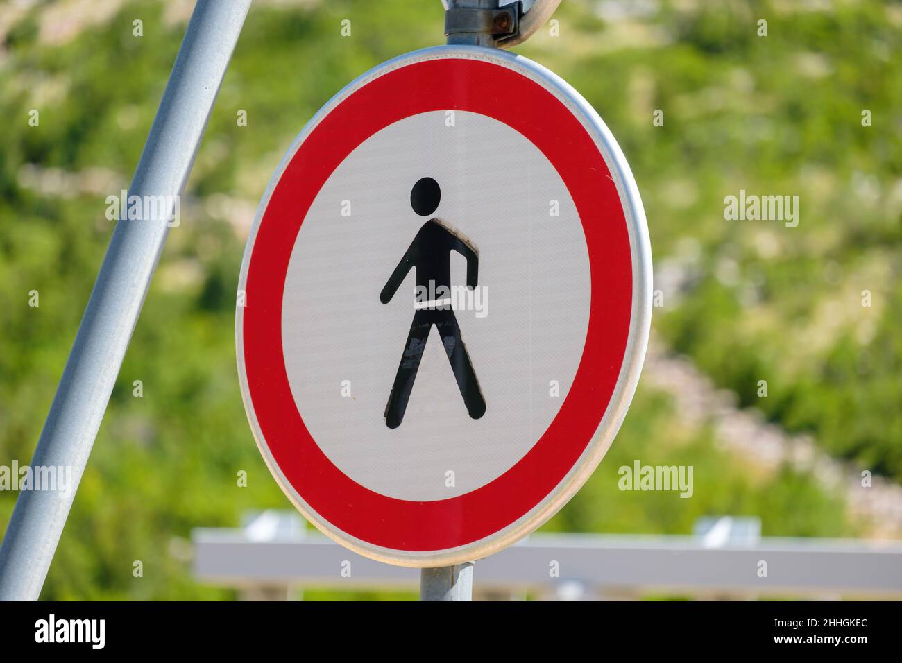 Traffic sign prohibited entry for people depicting a walking person inside a red circle.  Stock Photo