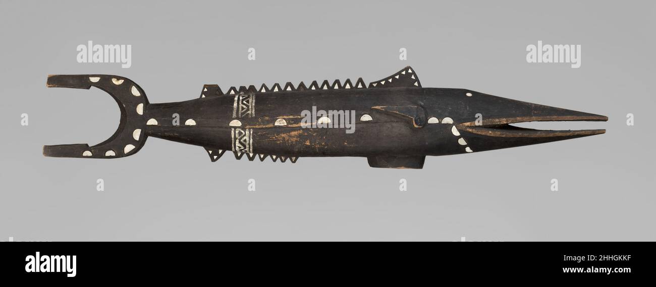 Shark Reliquary ca. 1900 Solomon Islands This is an extremely rare Solomon Islands shark reliquary carved from a single piece of wood with a hollowed cavity at its center which houses a human skull. They were placed high up in the rafters of the boathouse where the canoes were kept and where men gathered to discuss important community business. Reliquaries such as these are primarily associated with sharks but also incorporate features of the bonito fish (Sarda Chilensis) of the tuna family. The body of this shark-fish hybrid is long and slender, tapering at the head into a long snout with an Stock Photo