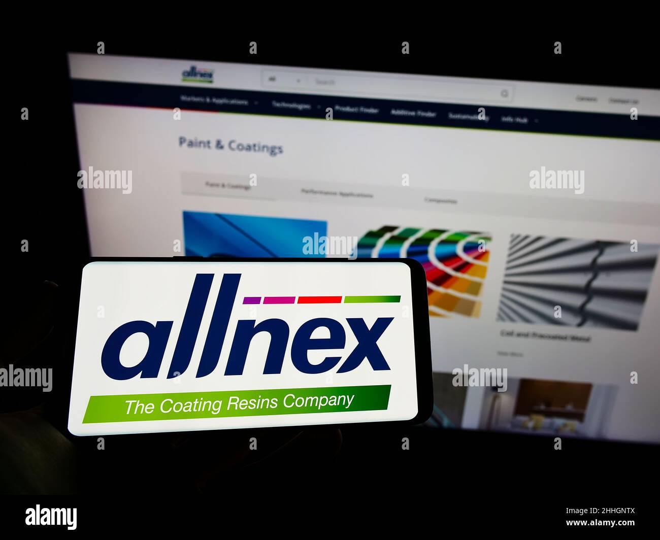 Person holding cellphone with logo of German chemicals company Allnex GmbH on screen in front of business webpage. Focus on phone display. Stock Photo