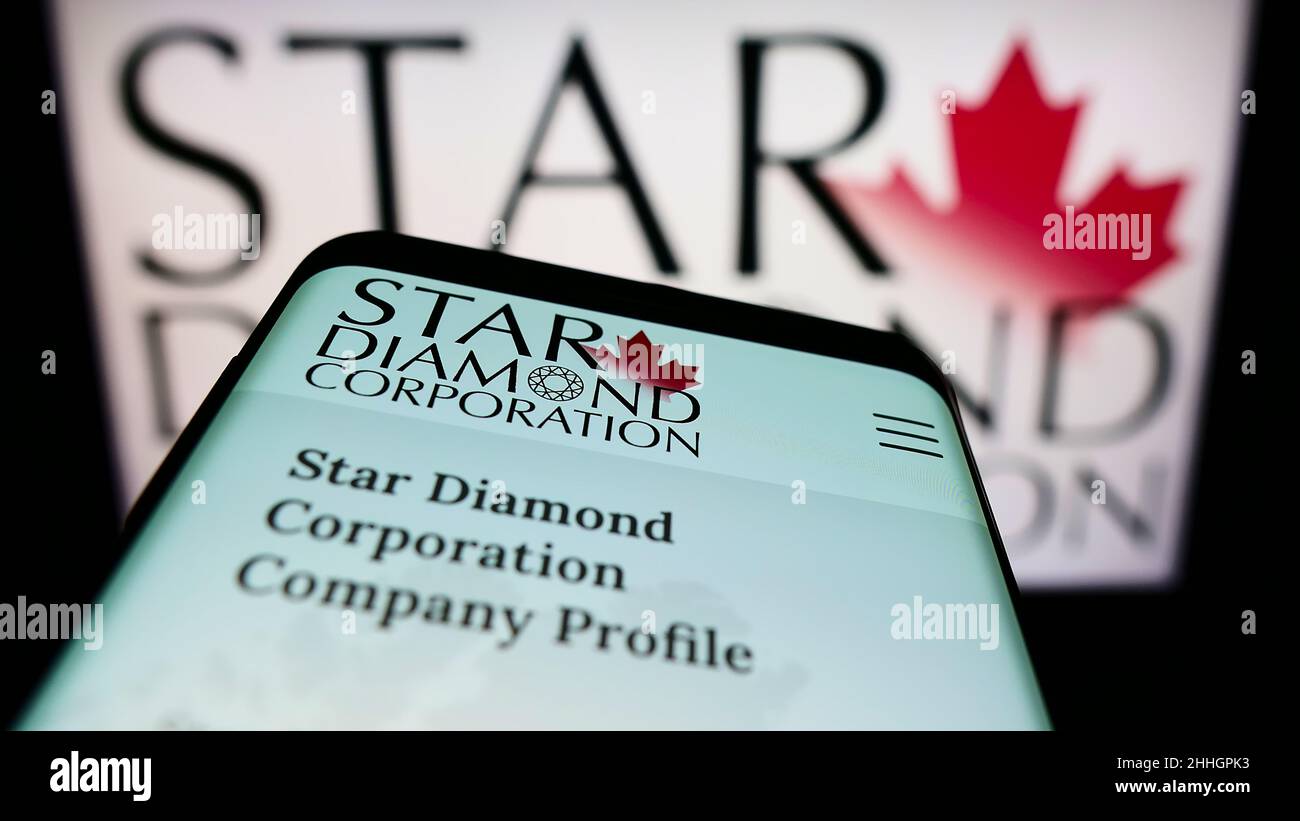 Mobile phone with webpage of Canadian mining company Star Diamond Corporation on screen in front of logo. Focus on top-left of phone display. Stock Photo