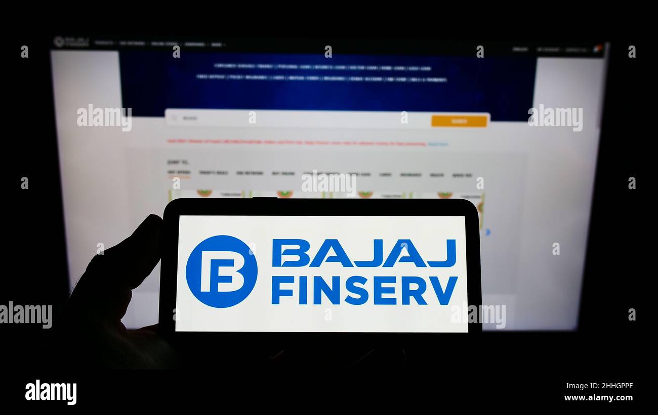 Person holding smartphone with logo of Indian financial company Bajaj