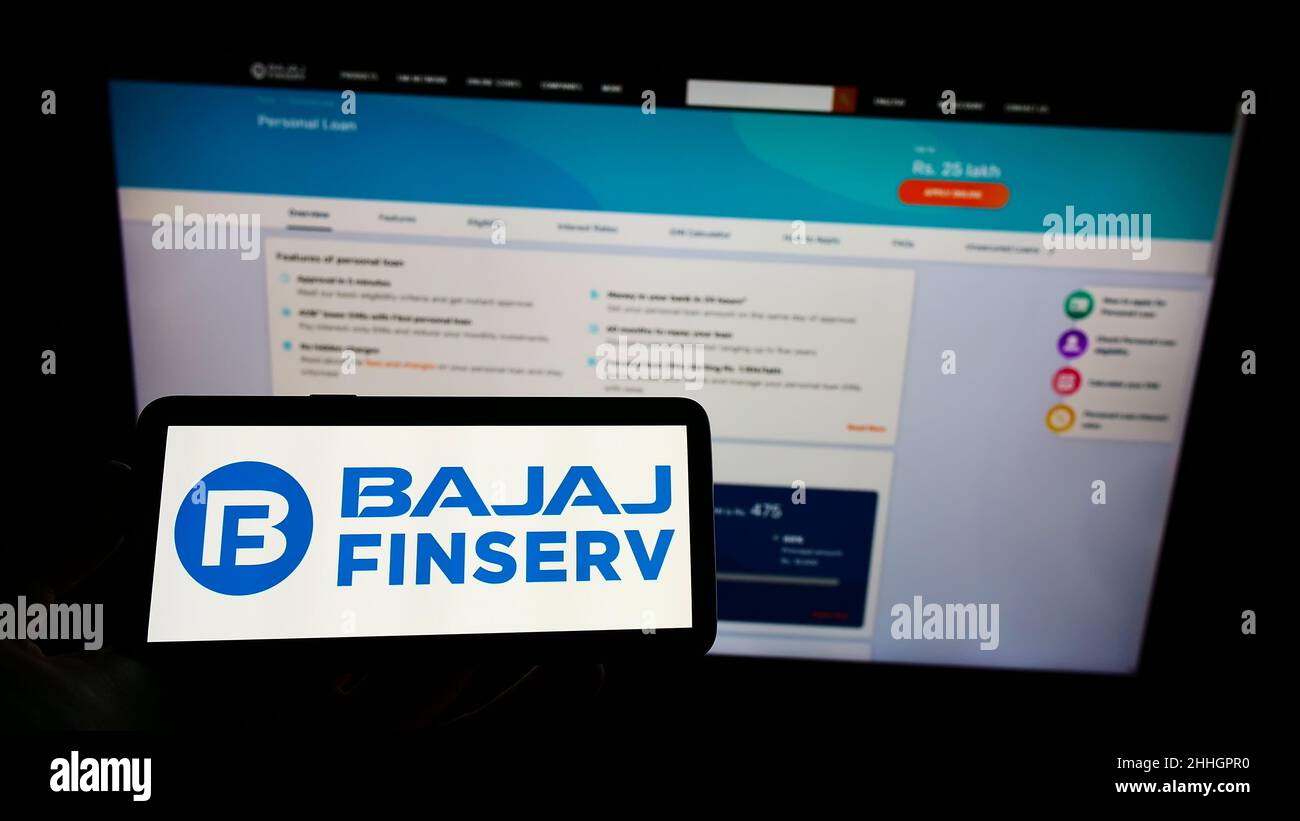 Person holding mobile phone with logo of Indian financial company Bajaj