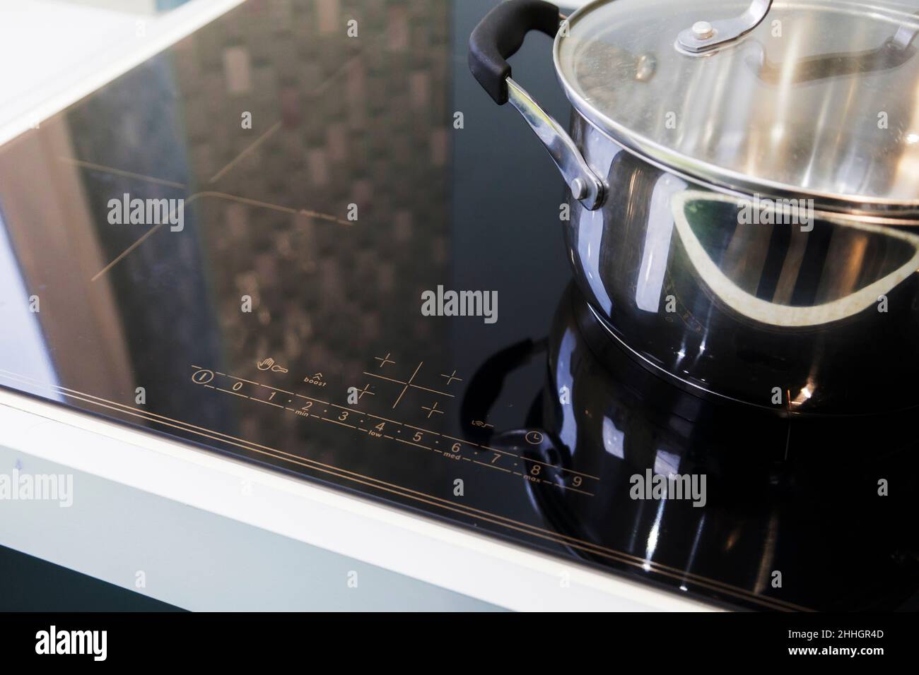Closeup of stainless steel pots on an induction cooker in a modern