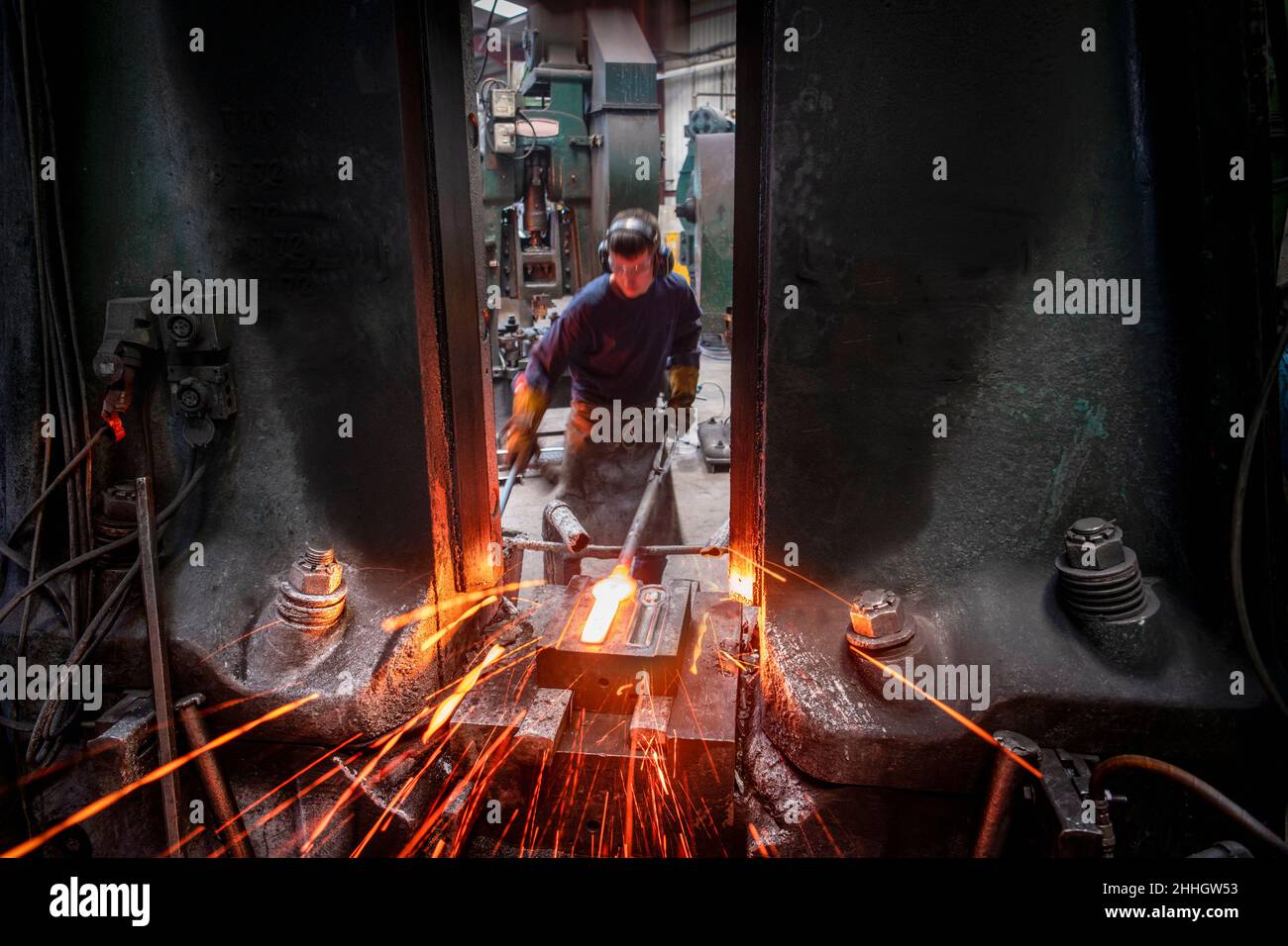 Engineer forging steel parts in hammer press in industrial forge Stock Photo