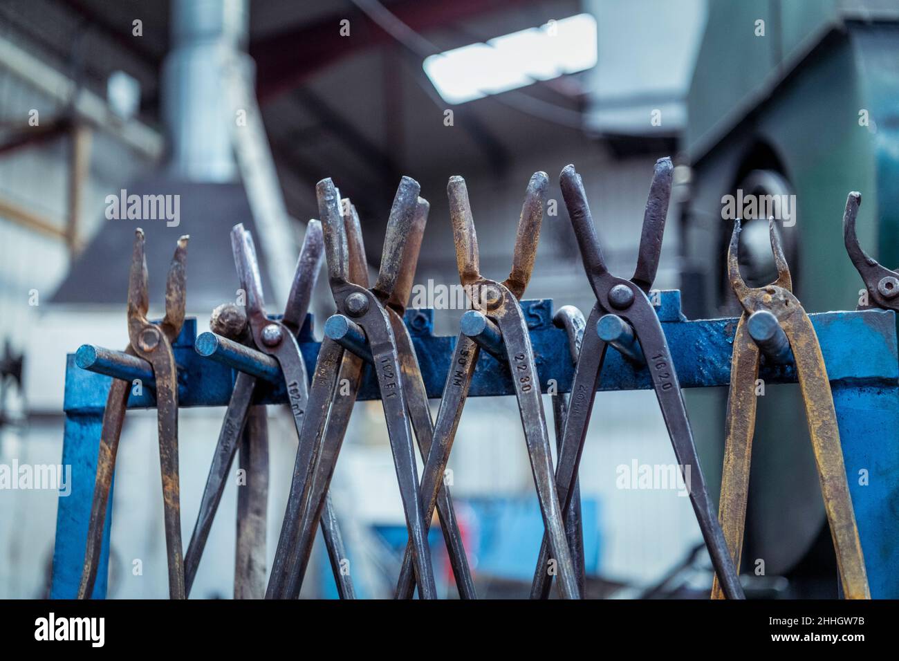 Row of tongs in industrial forge Stock Photo